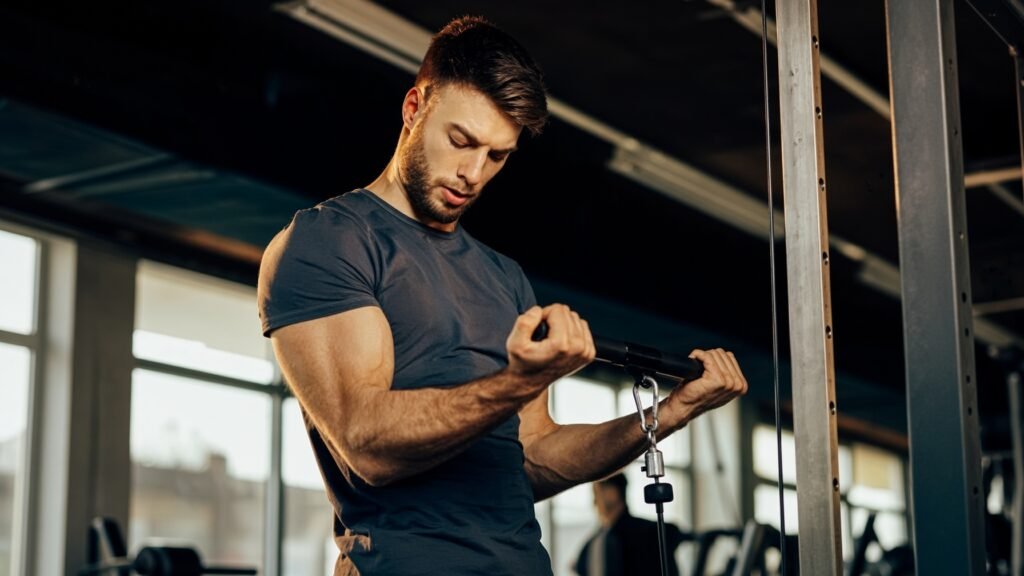 Man performing a cable bicep curl on a cable machine in a gym