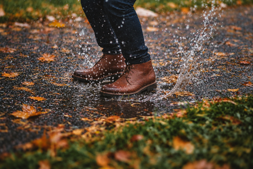 Brown leather boots on a wet sidewalk