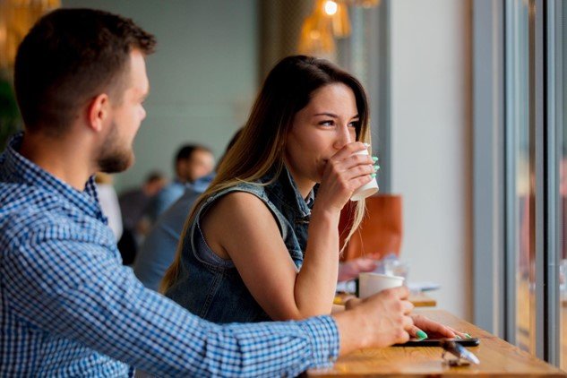 Man and woman sitting and talking at a coffee shop