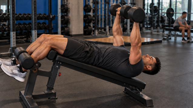 Man performing a decline dumbbell press on a bench set to a slight decline